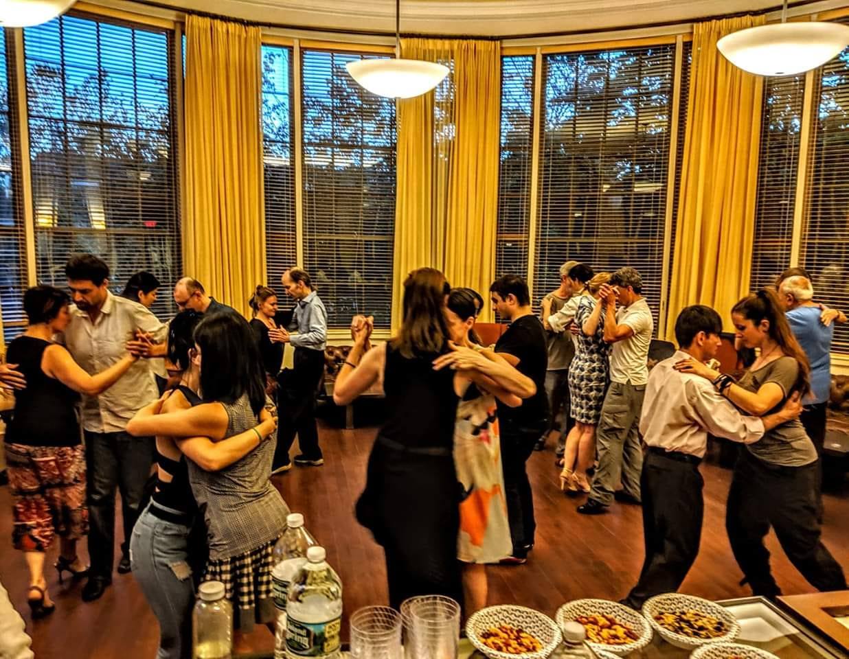 Ballroom with multiple pairs dancing together and a table with snacks is at the lower corner.