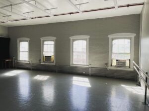 Photo of the Studio 414 with sun shining through 4 glass windows.