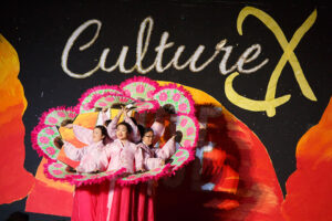 Culture X poster with multiple young dancers holding open fans in a circular formation.
