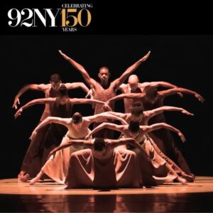 Photo of Alvin Ailey American Dance Theater in an iconic moment of "Revelations" in which the company is close together and in different levels so that as they open their arms the audience can see all of them.