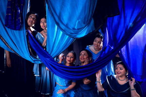 Photo of cast amidst blue fabric hanging