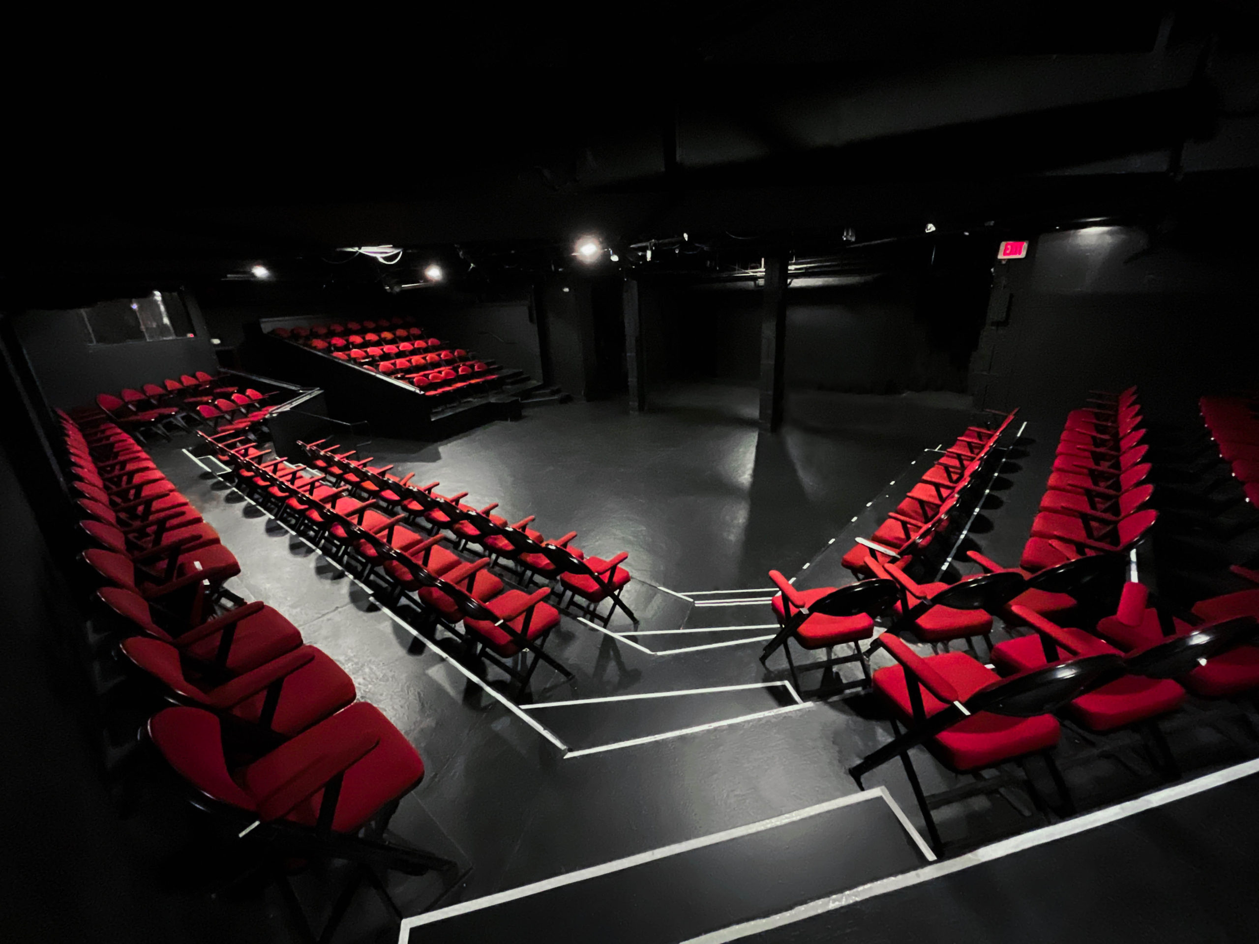 Photo of empty plaza theatre space with red chairs.