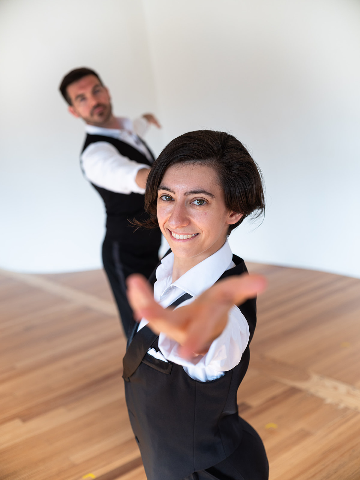 Photo of Holly Stone and Michael Winward dancing together. Holly reaches towards camera and smiles.