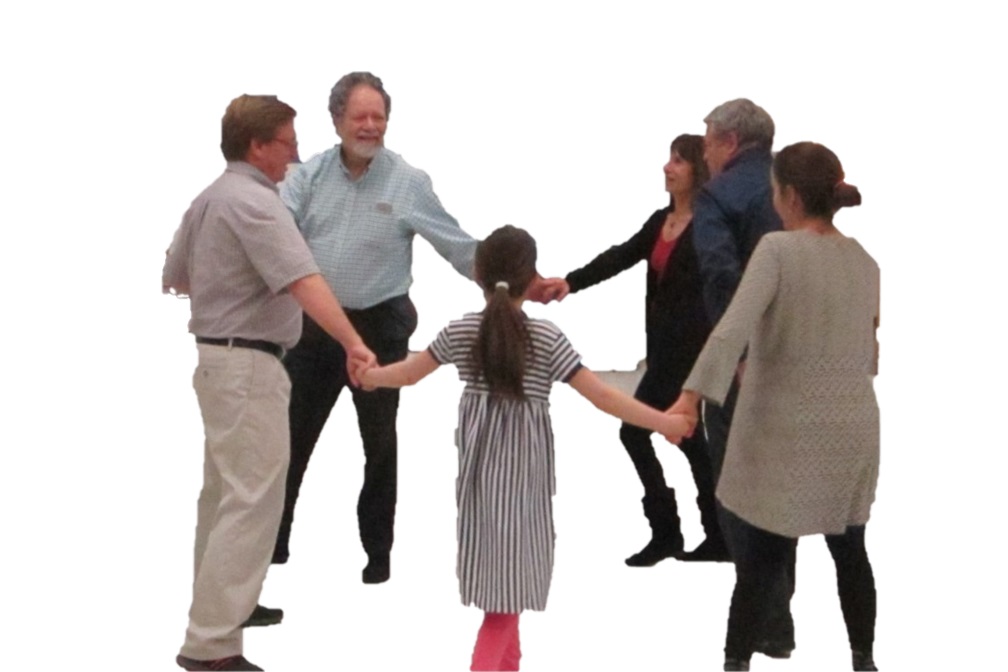 People dancing in a circle with hands joined.