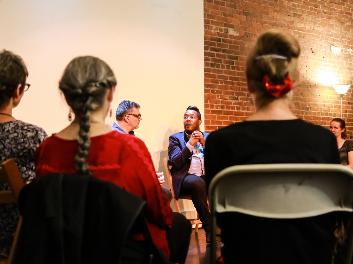 Photo of people sitting in a circle talking