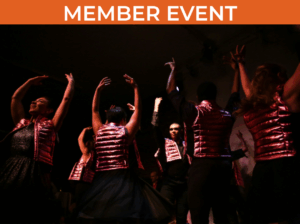 Several figures wearing metallic pink vests with arms upraised against a dark background