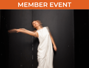 Woman in white gown moved in front of black backdrop, blurred by camera exposure