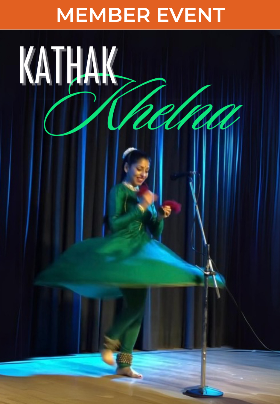 Smiling woman dancing Indian kathak dance, wearing a green raw silk dress with leggings, skirt flaring as she lands from a spin while playing hand cymbals with red tassels and wearing over 100 ankle bells. Standing in front of a black backdrop with a tinge of blue light on a light wooden stage.