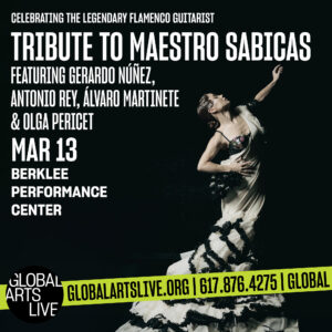 Olga Pericet dressed in white strikes a pose in dramatic dark lighting.